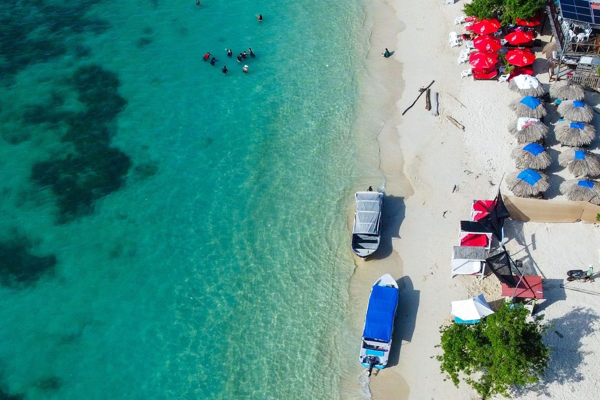 Playa caribeña con lanchas y sombrillas