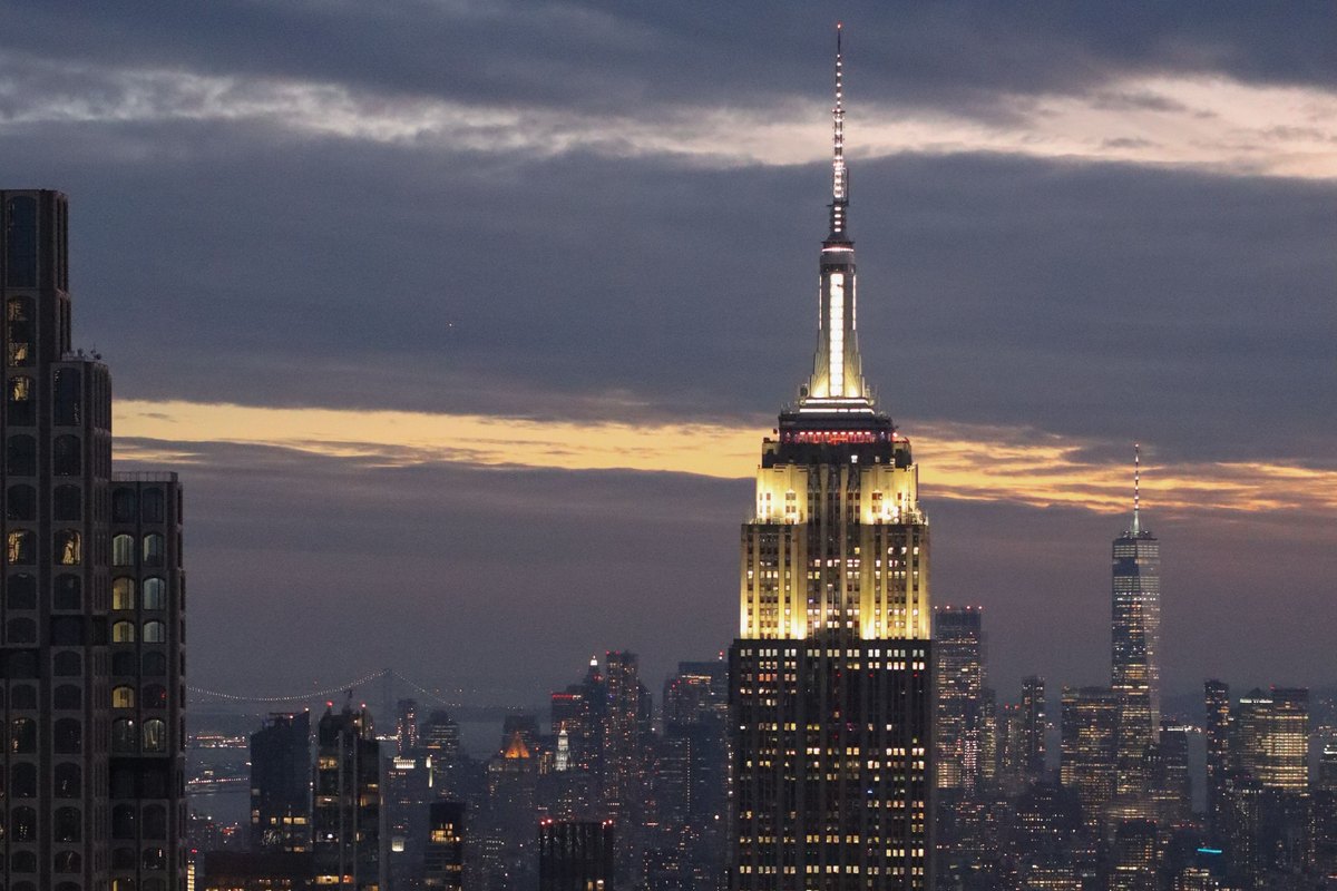 El Empire State Building iluminado al atardecer sobre el skyline de Manhattan