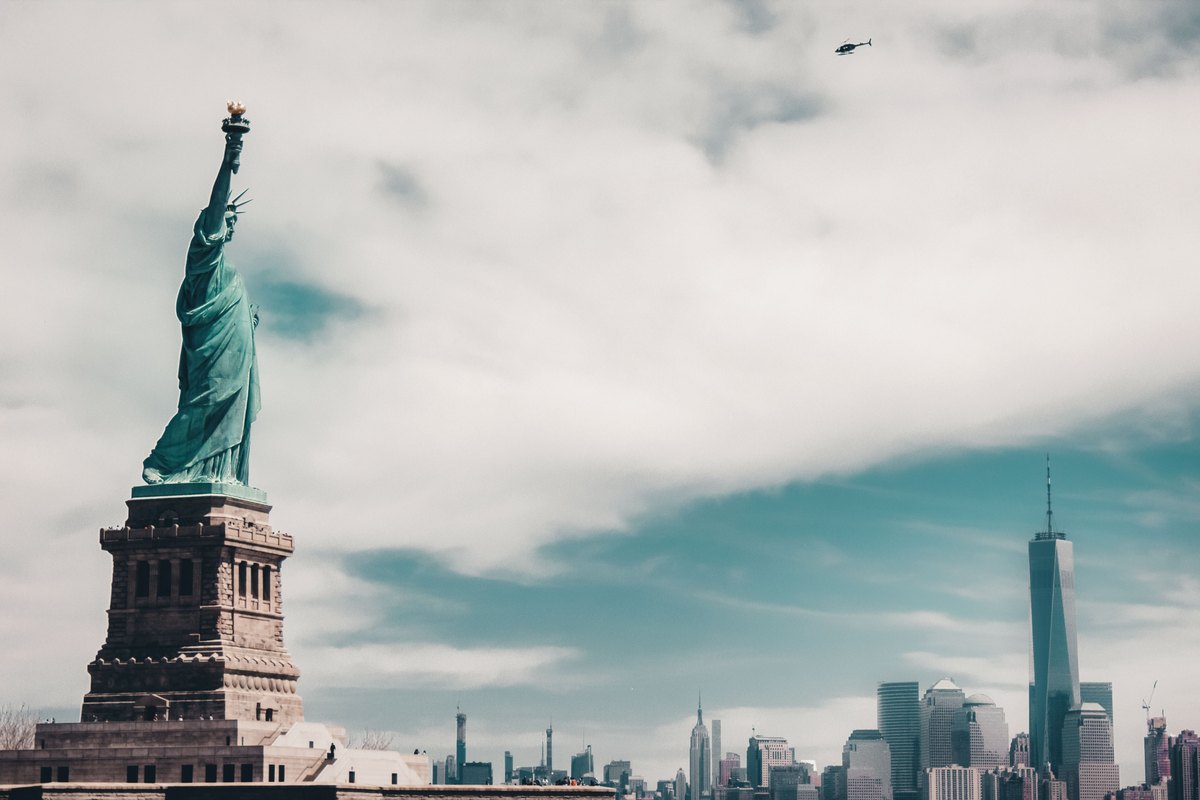 Estatua de la Libertad con el skyline de Manhattan y el One World Trade Center de fondo