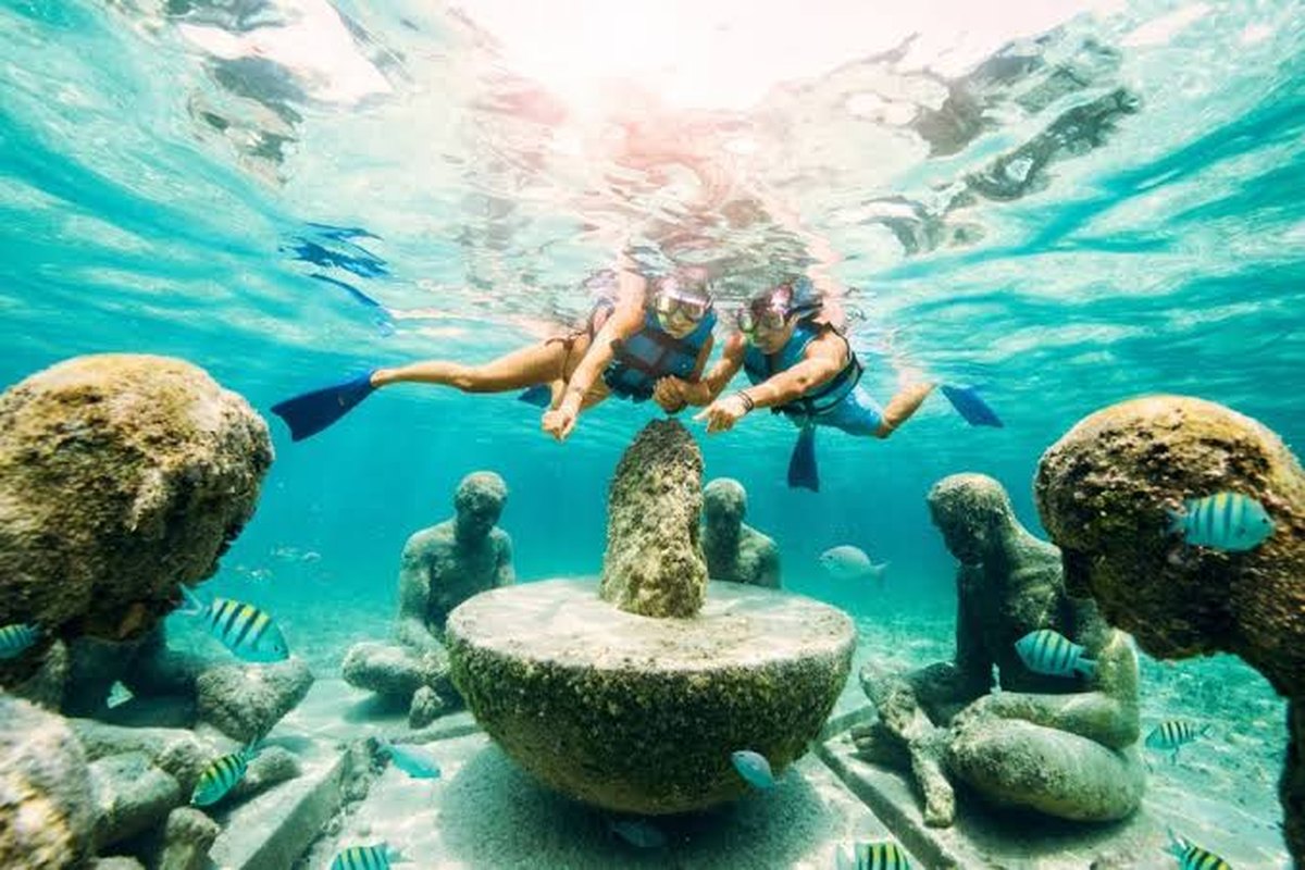 Pareja haciendo snorkel entre esculturas sumergidas en un tour de cayos