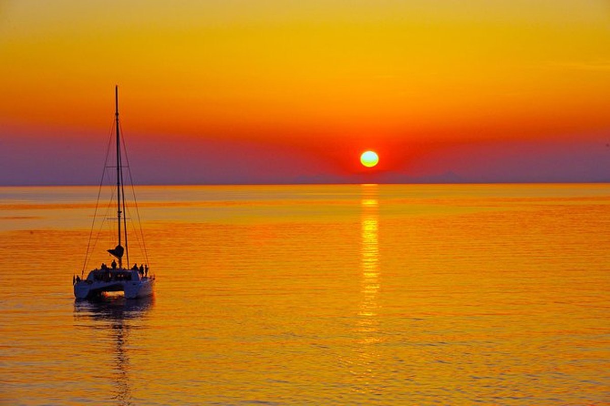 Catamarán navegando frente al atardecer en el mar Egeo